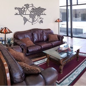 May include: A living room with two brown leather sofas, a glass-top coffee table, and a rug. The wall behind the sofas has a metal world map with a compass design.