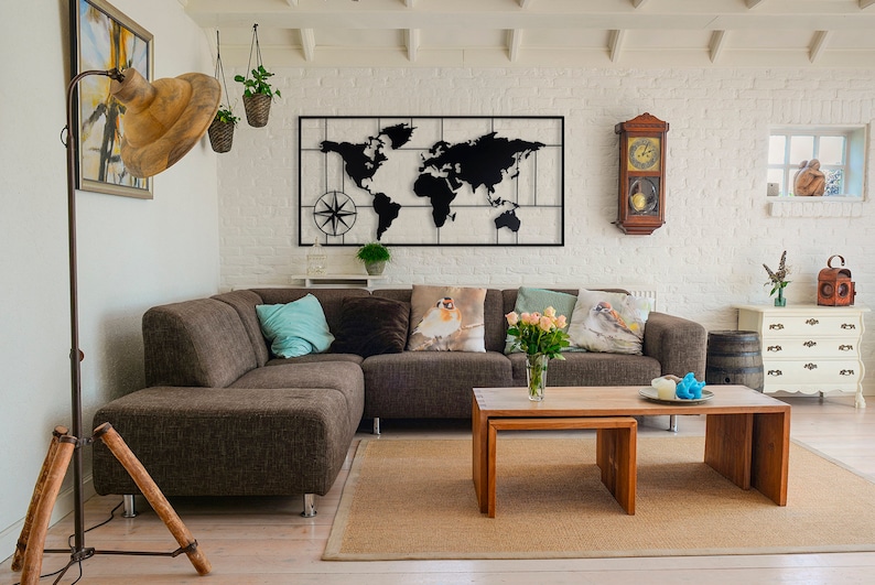 May include: A brown sectional sofa with pillows in a living room with a black metal world map wall decor, a wooden clock, and a wooden coffee table.