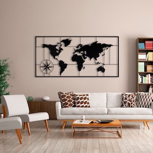 May include: A black metal world map wall decor with a compass design. The map is mounted on a white wall above a white sofa with brown patterned throw pillows. A wooden coffee table sits in front of the sofa.