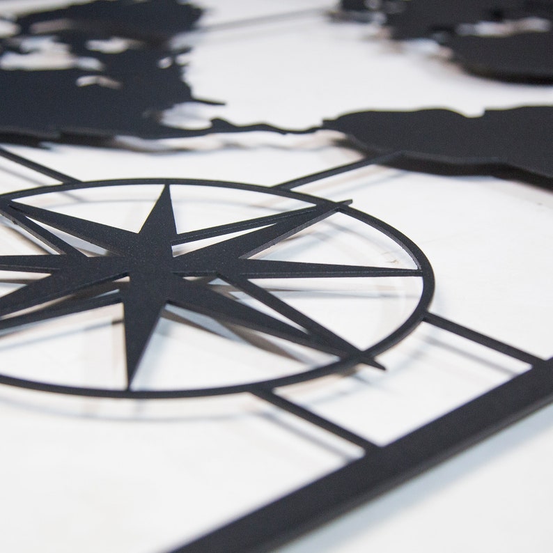 May include: Black metal world map wall art with a compass rose in the center.