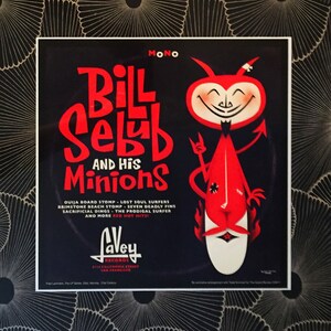 May include: A vintage record album cover featuring a red cartoon devil holding a surfboard. The album is titled "Bill Selby and His Minions" and features the song titles "Ouija Board Stomp", "Lost Soul Surfers", "Brimstone Beach Stomp", "Seven Deadly Fins", "Sacrificial Dings", "The Prodigal Surfer", and "More Red Hot Hits!" The album is by "Lavey Records" and is located at 2114 California Street, San Francisco.