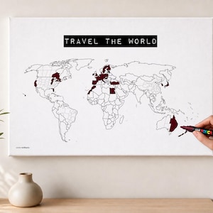 Könnte beinhalten: Ein weißes Leinwandbild mit einer schwarz-weißen Weltkarte und dem Text TRAVEL THE WORLD in einem schwarzen Rechteck. Mehrere Länder und Regionen sind in einer dunkelroten Farbe ausgefüllt, um besuchte Orte zu markieren.