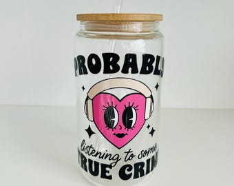 Probablemente estés escuchando algún crimen real. Bonito corazón rosa con auriculares, vaso de vidrio libre de vinilo UV-DTF envuelto a mano con tapa de bambú.