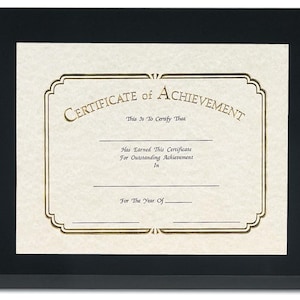 May include: A framed certificate with the words "Certificate of Achievement" in gold lettering. The certificate has space for details and is set against a cream-colored background within a black frame.