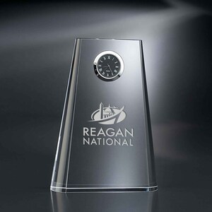 May include: A clear glass clock with a black face and silver hands. The clock is engraved with the words "Reagan National" and a logo of a building with a dome.