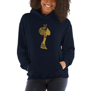 May include: A navy blue hoodie with a gold silhouette of a woman's head with intricate hair. The woman's face is turned to the side.