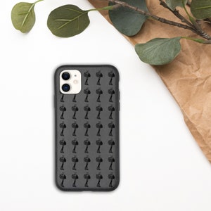 May include: A black phone case with a repeating pattern of small black trees. The case has a camera lens cutout and a white border around the camera lens.