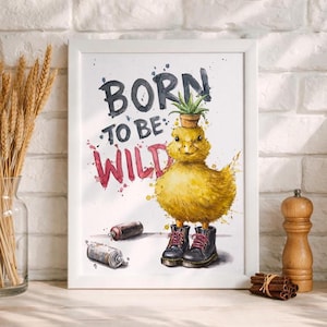 Könnte beinhalten: Ein gerahmter Aquarelldruck mit einem gelben Entlein, das schwarze Stiefel mit roten Schnürsenkeln und eine kleine Topfpflanze auf dem Kopf trägt. Der Text "BORN TO BE WILD" ist in schwarzer und roter Aquarellschrift dargestellt.