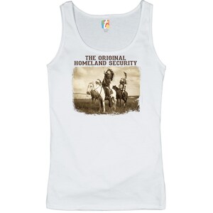May include: White tank top with a vintage-style image of two Native American men on horseback. The text "THE ORIGINAL HOMELAND SECURITY" is printed above the image.