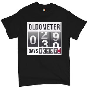 May include: Black t-shirt with a graphic of a digital odometer reading "02930" and "DAYS 10957".