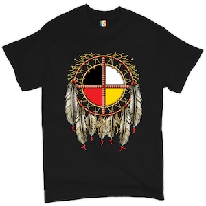 Puede incluir: Camiseta negra con un diseño de atrapasueños nativo americano con cuatro colores: negro, blanco, rojo y amarillo. El atrapasueños tiene plumas y cuentas colgando de él.