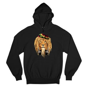Puede incluir: Sudadera con capucha negra con un gráfico de un león que lleva un sombrero rojo, verde y amarillo y auriculares.