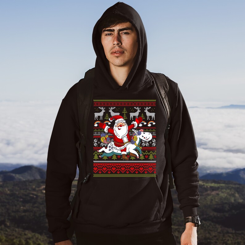 May include: A black hoodie with a Christmas-themed design featuring Santa Claus riding a unicorn. The design includes reindeer, rainbows, and snowflakes.