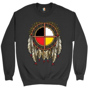 May include: Black sweatshirt with a Native American medicine wheel design. The wheel is made up of four colors: black, white, red, and yellow. It is surrounded by feathers.