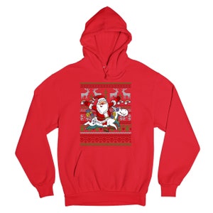 May include: Red hooded sweatshirt with a Christmas-themed design featuring Santa Claus riding a unicorn. The design includes reindeer, snowflakes, and hearts.