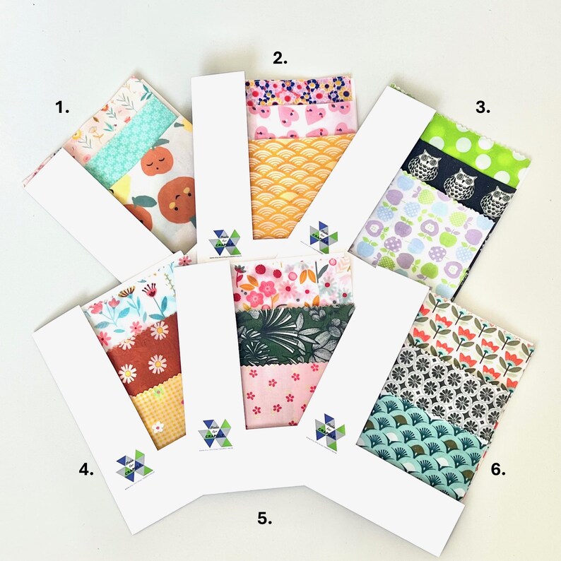 May include: Six sets of assorted fabric squares arranged in a fan pattern, each held by a white paper band labeled with a geometric logo. The fabric bundles feature various colorful patterns including floral, fruit, animal, and geometric designs.