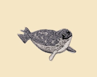 May include: A gray and white embroidered patch of a seal swimming. The seal is facing right and has a dark gray nose and eyes.