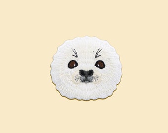 May include: White embroidered seal face patch with brown eyes and a black nose.