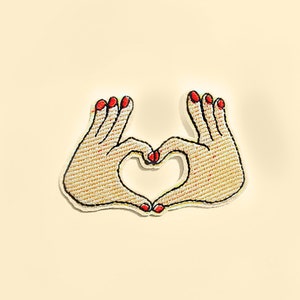 May include: Two hands forming a heart shape with red nail polish.