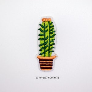 May include: Green embroidered cactus in a brown pot with orange accents. The cactus is 2.3 inches wide and 6 inches tall.