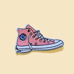 May include: Pink embroidered patch of a high-top sneaker with white laces and a blue star logo.