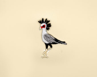May include: Embroidered iron-on patch of a gray and black secretary bird with a red eye.