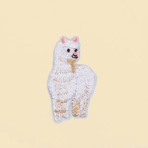 May include: White embroidered alpaca patch with pink ears and brown eyes.