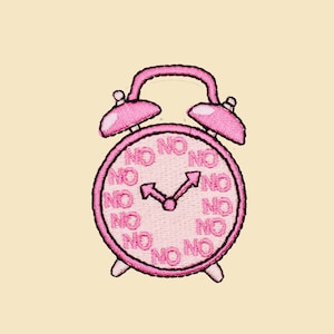 May include: Pink alarm clock with a white face and black hands. The clock face is surrounded by the word "NO" repeated multiple times.