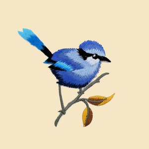 Peut inclure: Un oiseau bleu brodé perché sur une branche avec des feuilles jaunes et brunes. L'oiseau a une longue queue et un petit bec.