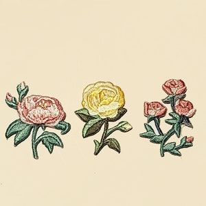 May include: Three embroidered iron-on patches featuring pink, yellow, and red roses. The patches are perfect for adding a touch of floral charm to clothing, bags, or other fabric items.