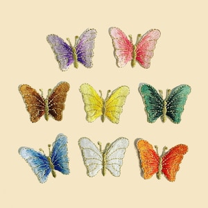 以下が含まれることがあります： 様々な色合いの刺繍されたアイロン接着式の蝶のアップリケ10個セット。紫、ピンク、茶色、黄色、緑、青、白、オレンジなどがあります。