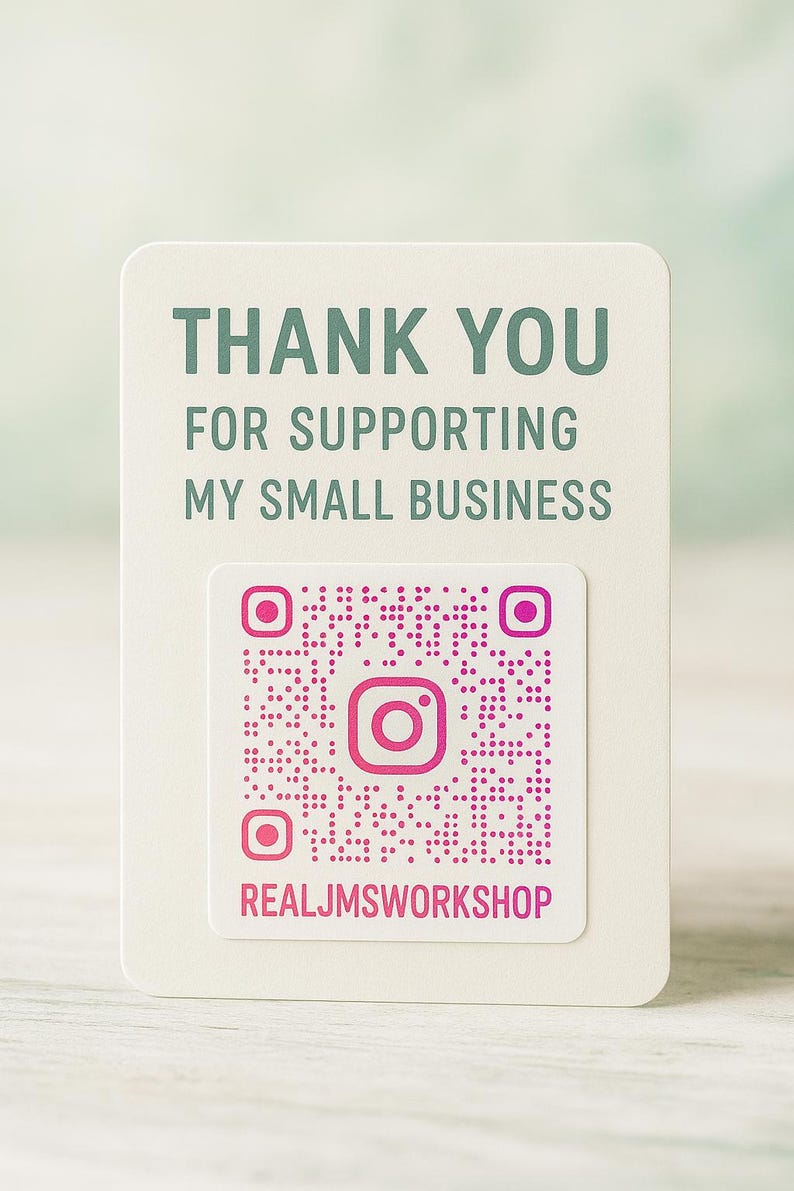 May include: A rectangular off-white card featuring the dark green text THANK YOU FOR SUPPORTING MY SMALL BUSINESS. Below the text is a square pink QR code with a central Instagram icon and the pink text REALJMSWORKSHOP printed underneath it.