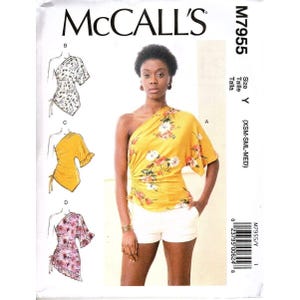 May include: McCall's M7955 sewing pattern envelope featuring a one-shoulder top with side ruching and tie detail. The cover displays a yellow floral top, white shorts, and three line-art sketches showing variations B, C, and D of the garment design.