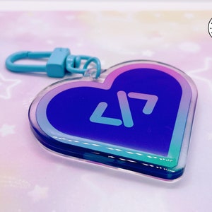 May include: A blue and purple heart-shaped keychain with a blue and white logo of two angled arrows. The keychain has a light blue metal ring.