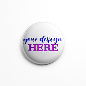 Puede incluir: Una chapa redonda de color blanco con el texto "your design" en una fuente cursiva azul situada sobre la palabra "HERE" en una fuente serif negrita de color magenta. La chapa tiene un acabado liso y brillante con borde redondeado.