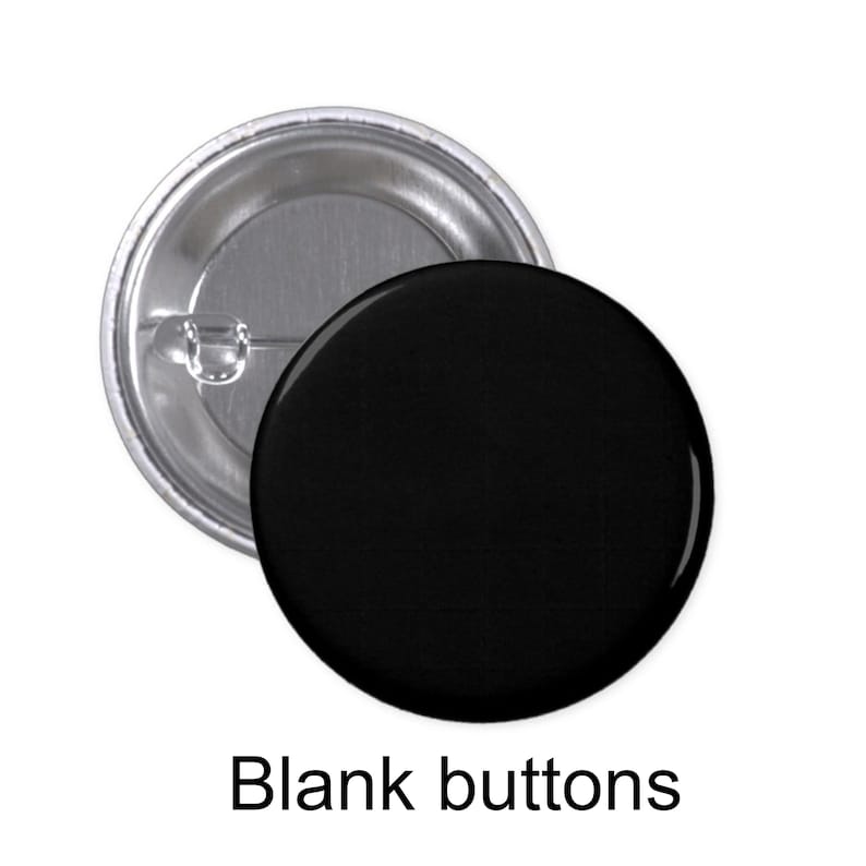 May include: Two blank round buttons, one silver and one black. The silver button has a pin back.