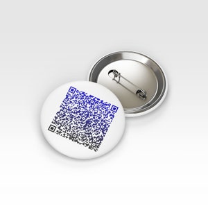 K&ouml;nnte beinhalten: Ein wei&szlig;er Knopf mit einem blau-schwarzen QR-Code darauf gedruckt. Der Knopf hat eine silberne R&uuml;ckseite mit einer Sicherheitsnadel.