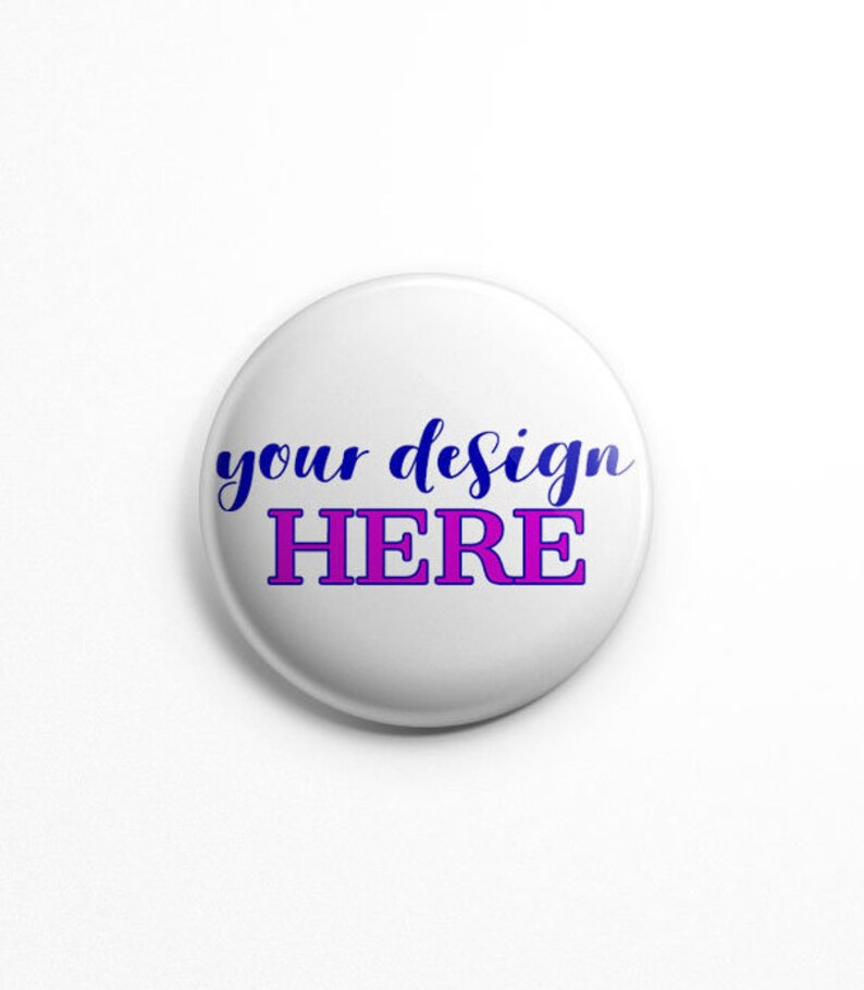 May include: White round button with the text "your design HERE" in blue and pink lettering.