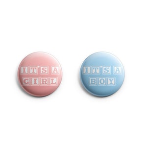 May include: Two round buttons with the text "It's a Girl" and "It's a Boy" in white letters on a pink and blue background, respectively.
