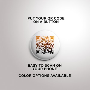 May include: A white button with a black and orange QR code. The text "PUT YOUR QR CODE ON A BUTTON" is above the button. The text "EASY TO SCAN ON YOUR PHONE" is below the button. The text "COLOR OPTIONS AVAILABLE" is below the second line of text.
