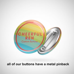 K&ouml;nnte beinhalten: Ein regenbogenfarbener Knopf mit dem Text "CHEERFUL REN" und "Custom Buttons" in Rot. Der Knopf hat eine Metall-R&uuml;ckseite.