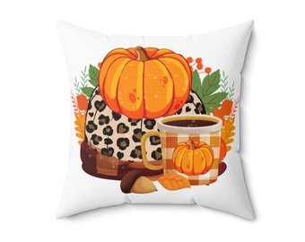Puede incluir: Una almohada blanca con un diseño de otoño que presenta una calabaza, una taza de café y una tela de estampado de leopardo. El diseño está rodeado de hojas de otoño y bayas.