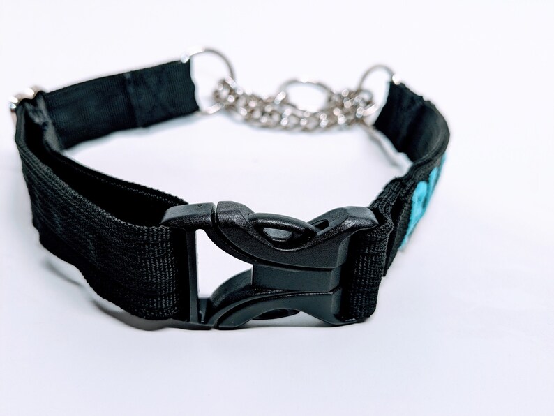 Puede incluir: Collar de perro de nylon negro con una hebilla de pl&aacute;stico negro y una cadena plateada. El collar tiene un dise&ntilde;o bordado azul.