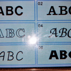 Puede incluir: Seis estilos de fuente diferentes para las letras ABC que se muestran en una pantalla azul. Los estilos de fuente incluyen negrita, serif, script y cursiva.