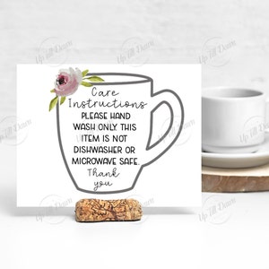 K&ouml;nnte beinhalten: Eine wei&szlig;e Karte mit einer grauen Umrandung einer Kaffeetasse und einem rosafarbenen Blumendesign. Die Karte lautet "Pflegehinweise Bitte nur von Hand waschen. Dieser Artikel ist nicht sp&uuml;lmaschinen- oder mikrowellengeeignet. Danke".