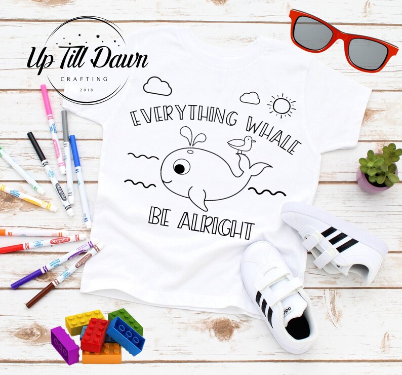 Pode incluir: Camiseta branca com uma ilustra&ccedil;&atilde;o em preto e branco de uma baleine com um p&aacute;ssaro no topo. O texto "Everything Whale Be Alright" est&aacute; escrito acima e abaixo da baleine.