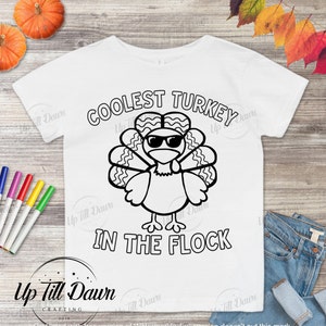 May include: A white t-shirt with a black and white illustration of a turkey wearing sunglasses. The text "Coolest Turkey in the Flock" is printed below the turkey.
