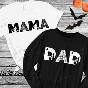 Könnte beinhalten: Zwei schwarz-weiße T-Shirts mit den Worten "MAMA" und "DAD" im Halloween-Stil. Die Buchstaben sind mit einem Spinnennetz und einer Hexe auf einem Besen verziert.