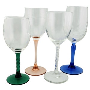 May include: Four clear glass wine glasses with twisted stems. The glasses have different coloured stems: green, pink, blue, and clear.