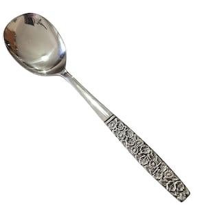 Puede incluir: Una cuchara de servir plateada con un cuenco grande y ovalado y un mango largo. El mango presenta un detallado patrón floral. La cuchara está hecha de un metal brillante y reflectante, probablemente acero inoxidable o plata, para servir alimentos.